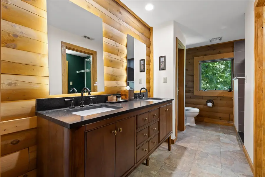 Bathroom with a long double vanity and dark stone counter