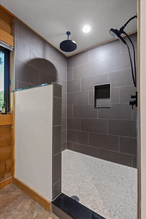 Large walk-in tiled shower with pebble floor