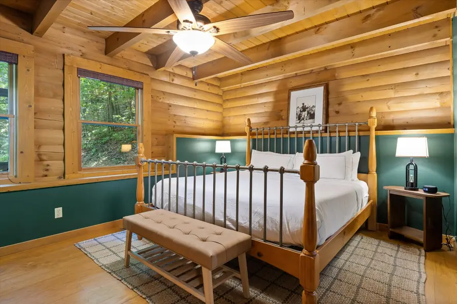 Four-poster king bed in a green and cedar bedroom