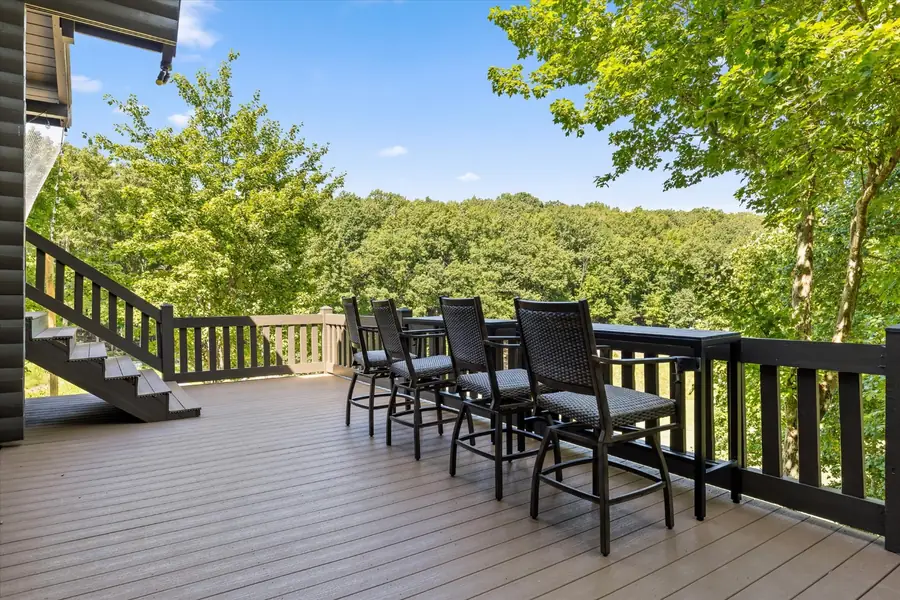 Long row of outdoor dining chairs along the deck railing