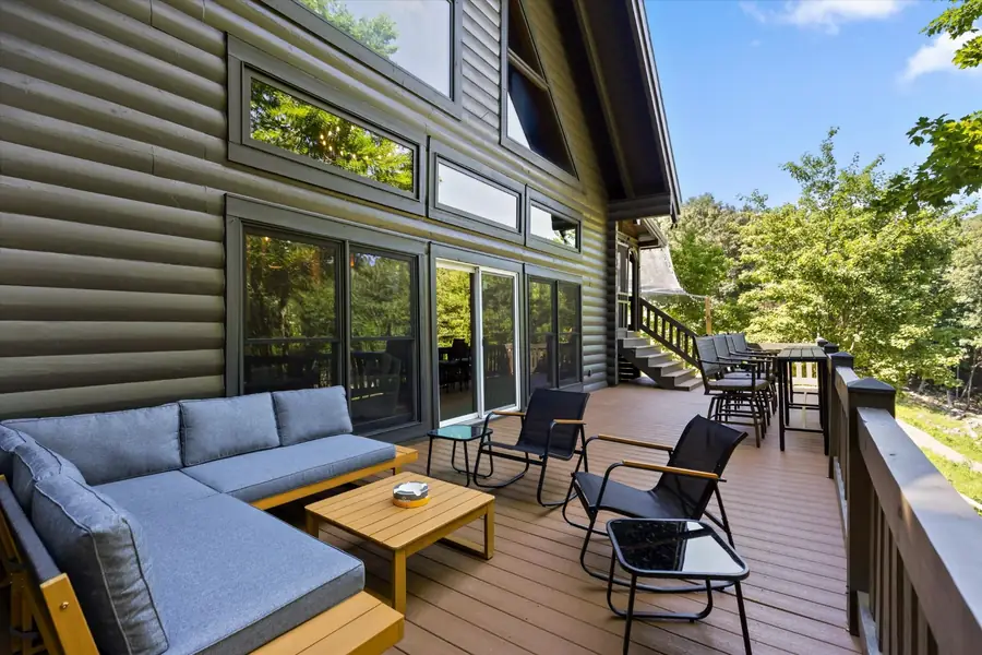 Outdoor sectional and coffee table on a wide deck with railing
