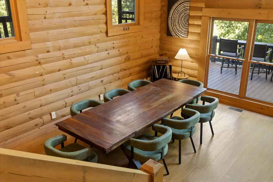 Long walnut dining table with teal chairs under a chandelier