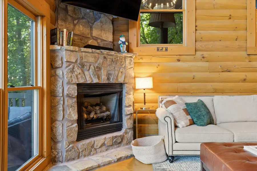 Stone fireplace with mantel beside a cream sofa