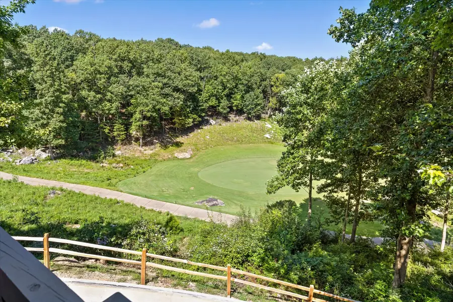 View from the deck across a mowed fairway framed by trees