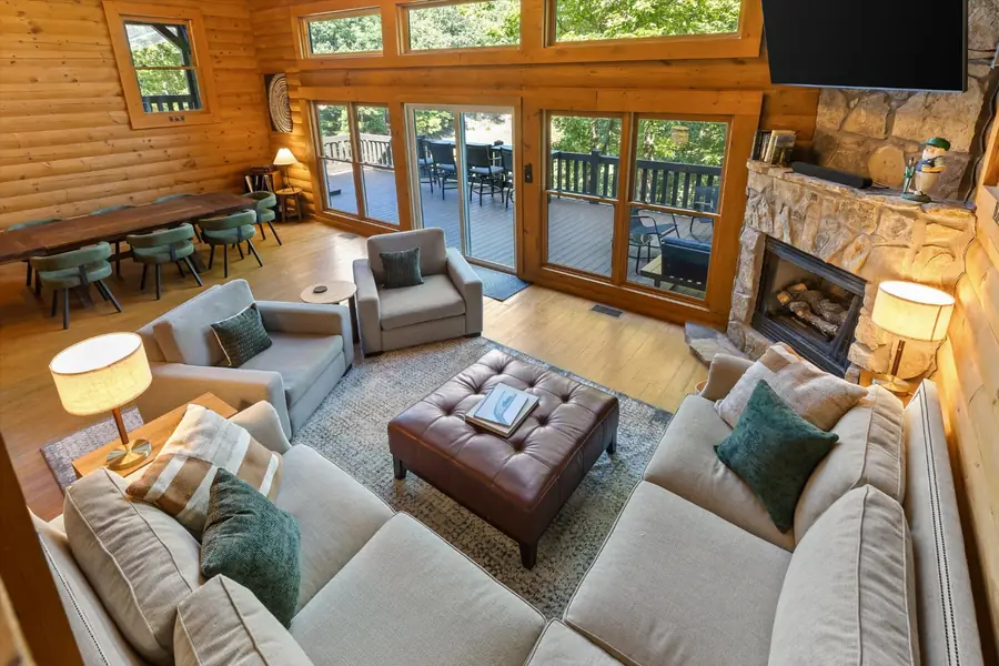 Great room with sectional sofa, stone fireplace and wall of windows