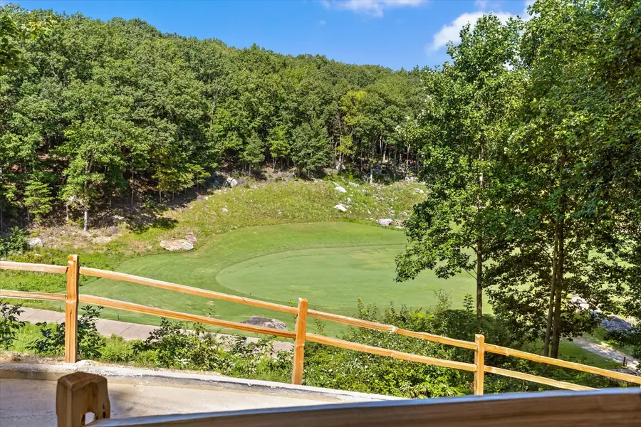 Manicured golf green seen from above through the trees