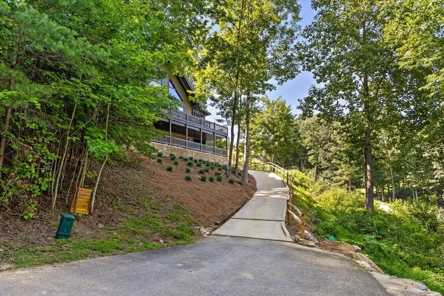 The home seen from the concrete driveway among trees
