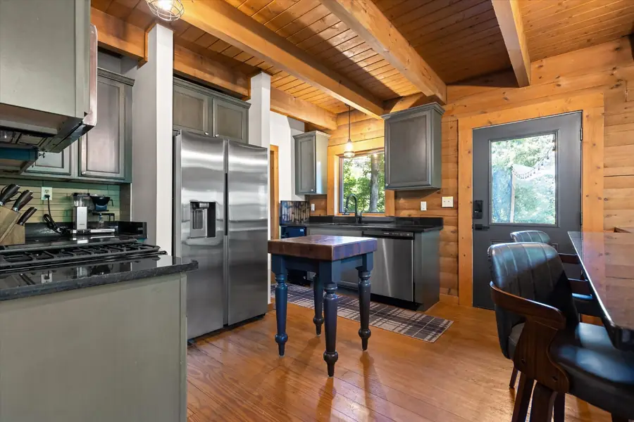 Open kitchen with stainless appliances and butcher-block island