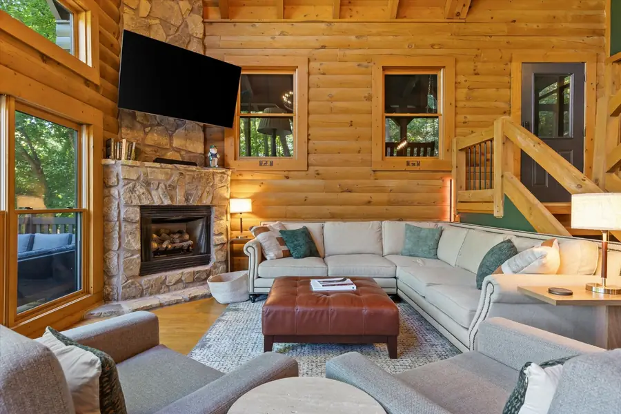 Living area with stone gas fireplace and mounted television