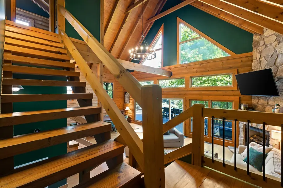 Open wood stair rising to the loft with log railings