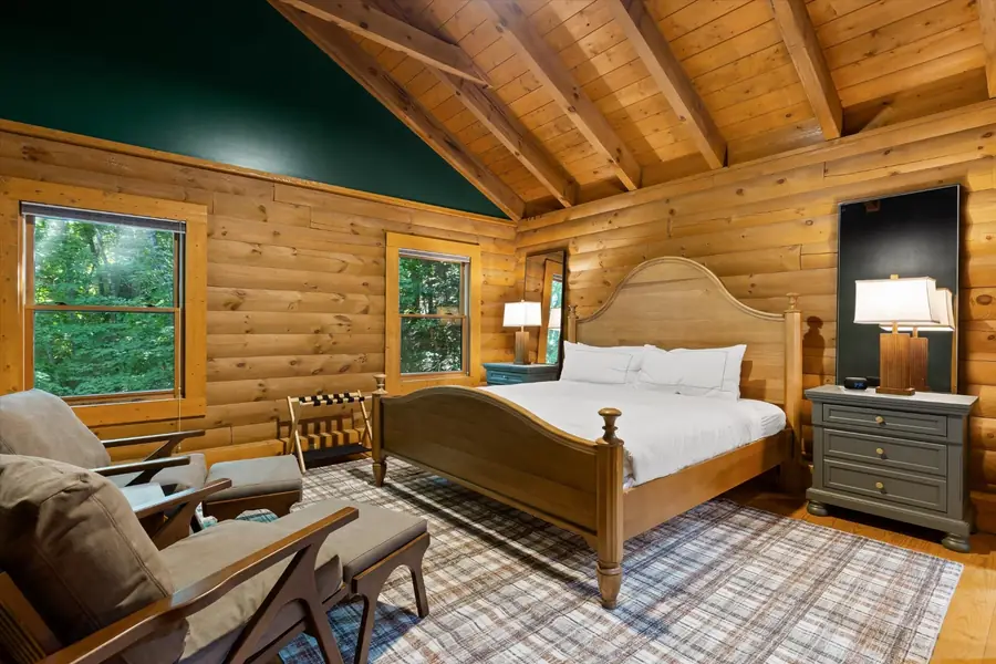 Upper suite with king bed, sitting area and vaulted cedar ceiling